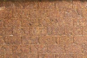 flou de mur de briques de latérite rouge motif de fond poreux et à grain fin photo