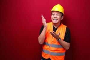 sourire et heureux jeune travailleur asiatique est avec le point de la main sur l'espace vide photo