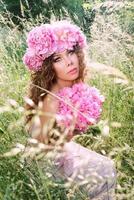 belle femme caucasienne avec une couronne de pivoines roses sur la tête. printemps, fleur, concept de fée photo