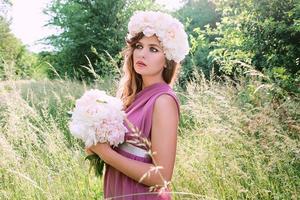 belle femme caucasienne avec une couronne de pivoines sur la tête. printemps, fleur, concept de fée photo