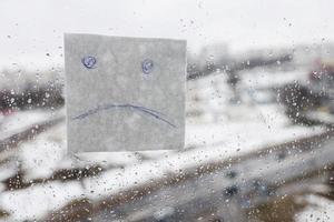 émoticône triste sur la fenêtre. photo