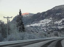 conduite au lever du soleil à travers les montagnes et le village de norvège. photo