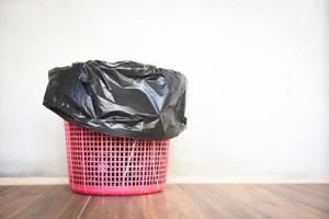 poubelle , déchets d'ordures et sac en plastique noir - corbeille sur fond de mur photo