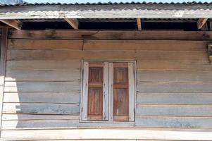 fenêtres en bois anciennes et vieux toits de murs en bois en tôle galvanisée. photo