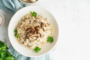 risotto aux champignons en assiette. bouillie de riz aux champignons et persil photo