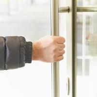 l'homme prend la poignée de porte avec sa main et ouvre la porte. lieu d'accumulation du coronavirus, covid-19 photo