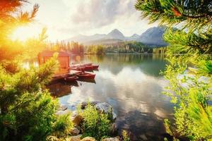 bateau sur le quai entouré de montagnes. fantastique shtrbske pleso photo