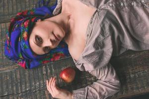 Triste femme mûre en coiffure nationale ukrainienne avec apple photo