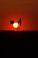 coucher de soleil derrière un moulin à vent en saskatchewan photo