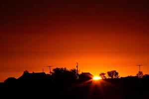 soleil levant derrière une ferme de la saskatchewan photo