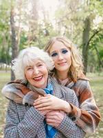 femme senior avec jeune fille marchant en plein air au printemps. famille, génération, soins, amour, concept de vaccination photo