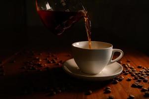 café chaud à partir de grains de café frais prêts à boire dans une tasse à café blanche.