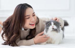 jeune femme asiatique jouant avec un chat à la maison photo