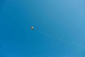 cerf-volant arc-en-ciel coloré dans le ciel bleu photo
