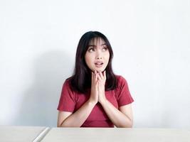 jeune femme asiatique pensant geste regardant au-dessus isolé sur fond blanc photo