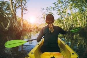 kayak de voile femme dans la forêt de mangrove contre la belle lumière du soleil photo