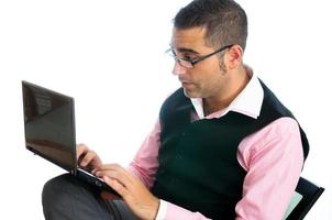 homme d'affaires prospère avec des lunettes portant un gilet et une chemise rose regardant un petit ordinateur photo