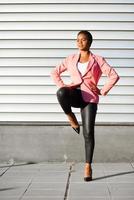 femme noire, modèle de mode, debout sur un mur urbain photo