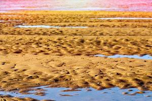 sable après marée basse sur une plage de cantabrie, espagne. image horizontale.