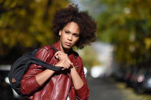 jeune femme noire avec une coiffure afro debout en arrière-plan urbain photo