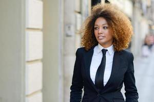 femme d'affaires noire portant costume et cravate en arrière-plan urbain photo