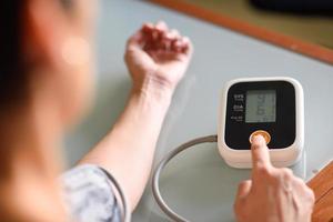 femme mesurant sa propre tension artérielle à la maison. photo