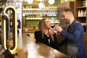 couple multiethnique proposant des toasts dans un pub photo