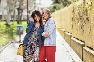 deux amies heureuses de jeunes femmes se serrant dans la rue. photo