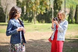deux jeunes femmes touristiques prenant des photos à l'extérieur