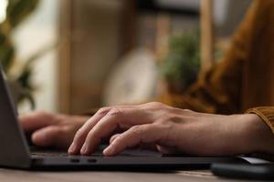 gros plan main tapant sur le clavier d'un ordinateur portable lorsque vous vous réveillez à la maison photo