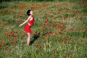 une fille vêtue de rouge dans un champ de coquelicots photo