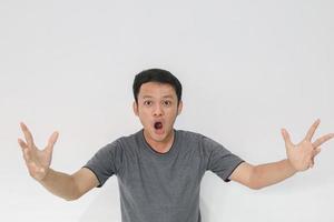 wow et visage choqué d'un jeune homme asiatique avec un geste de la main ouverte. concept de modèle publicitaire. photo