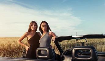 deux femme brune sexy debout près de sa voiture photo