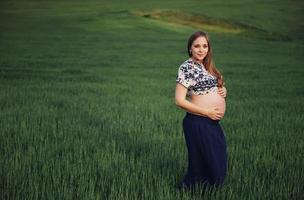 femme enceinte dans un champ de blé vert photo