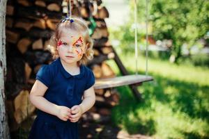 jeune fille avec papillon de peinture de visage. photo