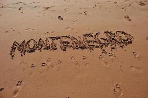 monténégro écrit dans le sable sur la plage photo