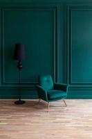 belle salle intérieure de luxe classique bleu vert propre dans un style classique avec fauteuil vert doux. chaise bleu-vert antique vintage debout à côté du mur émeraude. conception de maison minimaliste. photo