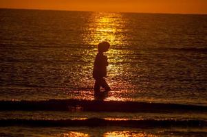 fille qui marche au coucher du soleil photo