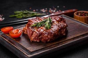 steak de boeuf ribeye grillé, herbes et épices sur une table sombre photo