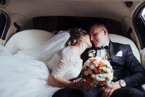 jeune couple dans une voiture le jour du mariage photo