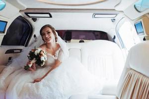 portrait d'une belle jeune mariée dans la voiture photo