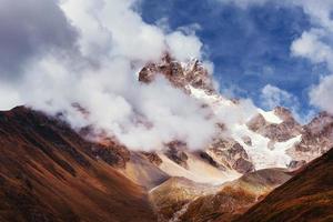 paysage d'automne et montagnes enneigées dans de beaux cumulus. photo