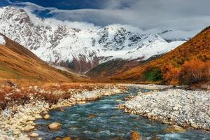 montagnes enneigées et rivière de montagne bruyante. géorgie, svanétie. euro photo