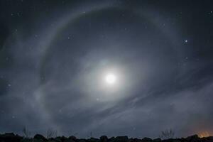 halo lune s'élève au-dessus des rochers la nuit photo