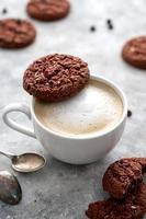 café et biscuits. avoine, biscuits sains et tasse à café avec mousse de lait, concept de petit-déjeuner. photo