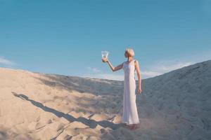 femme blonde dans le désert avec des poissons rouges dans les mains photo