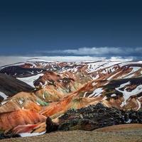 beau paysage islandais de montagnes volcaniques arc-en-ciel colorées de landmannalaugar, célèbre sentier de randonnée de laugavegur avec ciel dramatique et sol volcanique rouge en islande, fond d'espace de copie dégradé. photo