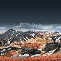 beau paysage islandais de montagnes volcaniques arc-en-ciel colorées de landmannalaugar, célèbre sentier de randonnée de laugavegur avec ciel dramatique et sol volcanique rouge en islande, fond d'espace de copie dégradé. photo