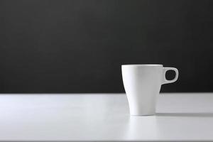 tasse blanche sur fond gris. tasse en céramique vierge photo