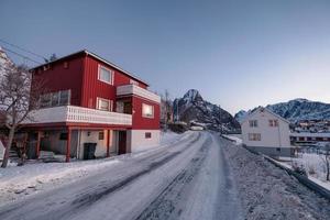 maison rouge avec montagne enneigée dans un village de pêcheurs en hiver photo